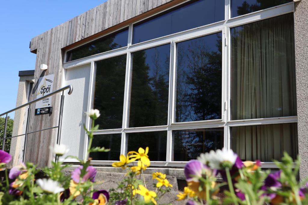 a window of a building with flowers in front of it at Spói Guesthouse in Hvolsvöllur