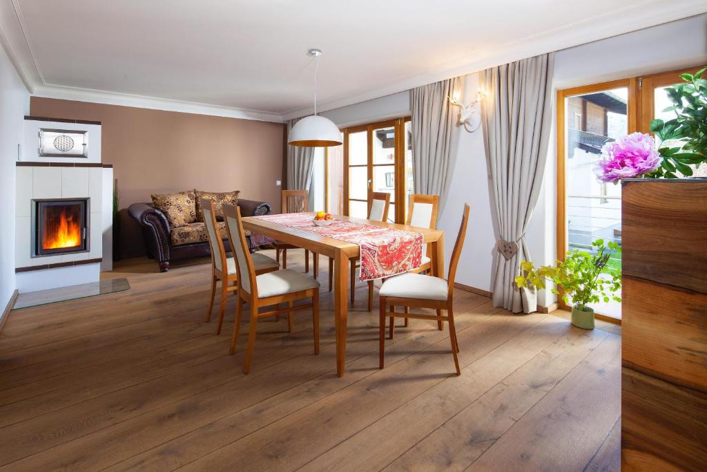 a dining room with a table and chairs and a fireplace at Sonnenschein in Bischofswiesen