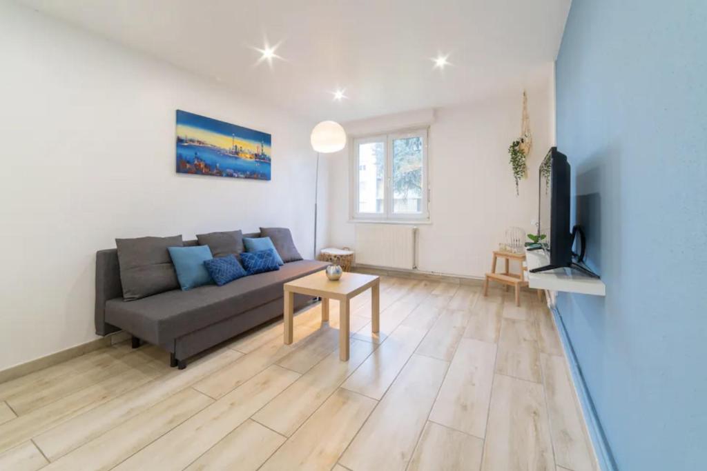 un salon avec un canapé et une table dans l'établissement JUST FOR YOU - Balcon - Parking - Calme- Fibre - RELAX BNB, à Mulhouse