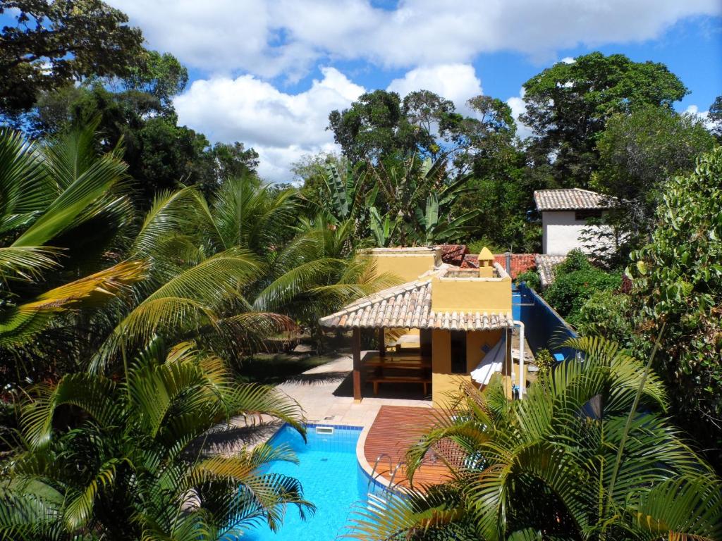 a resort with a swimming pool and palm trees at Casa da Arvore Apartamentos Pousada in Arraial d'Ajuda