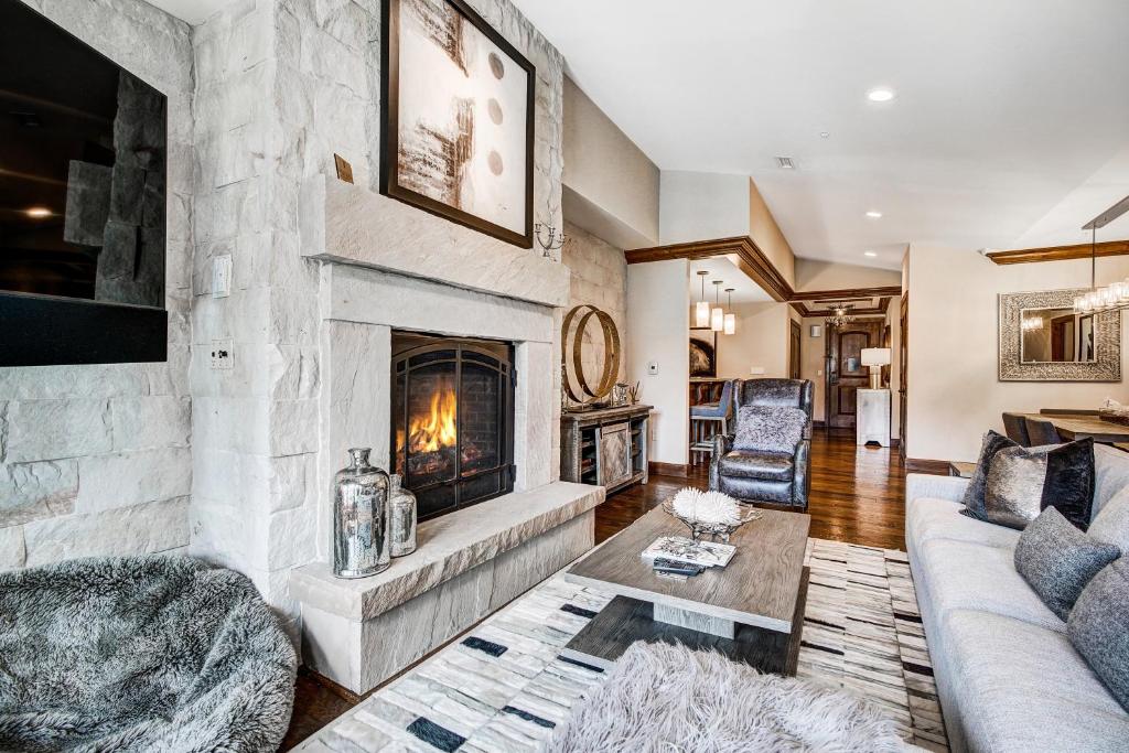 a living room with a large stone fireplace at Ritz 2Br R614 in Vail