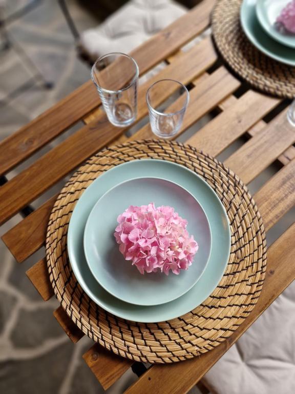 a plate with a pink flower on a table at Palorto Traditional Hotel in Gjirokastër