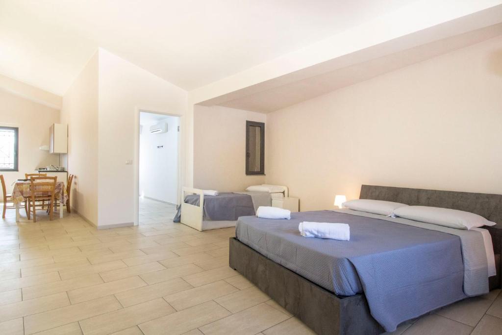 a large bedroom with two beds and a dining room at Royal Playa Suite and Apartament -private parking- self chek out in Catania