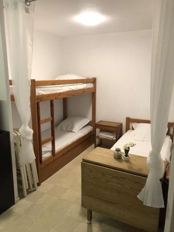 une chambre avec deux lits superposés et une table dans l'établissement Studio avec parking privé, au Grau-du-Roi