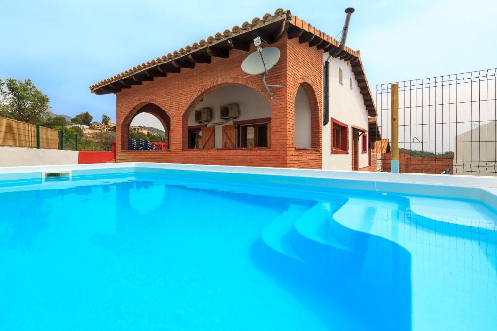 a house with a swimming pool in front of a building at Can Prats in Ríudecañas