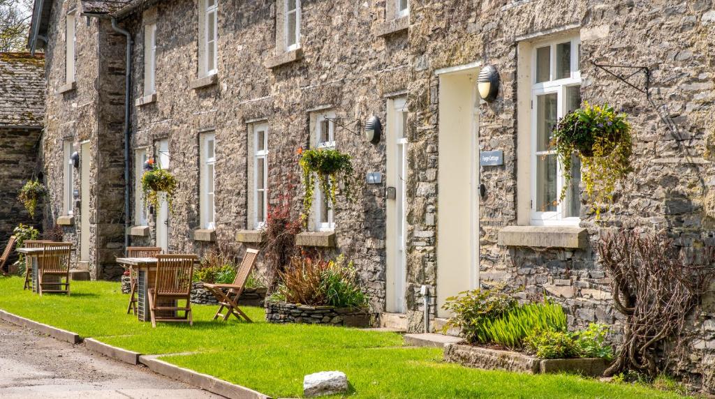 a stone house with a lawn in front of it at Forge Cottage in Rusland