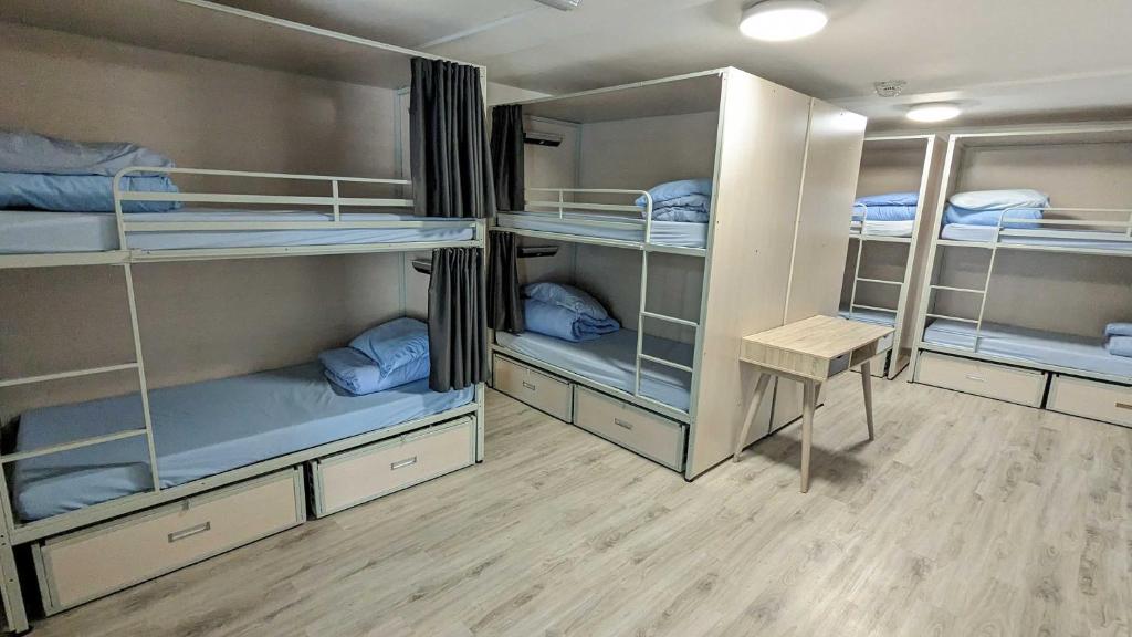 a room with four bunk beds with blue pillows at International Inn in Liverpool