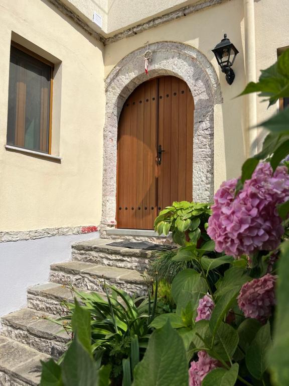 una puerta de madera en una casa con flores en Palorto Hotel, en Gjirokastra