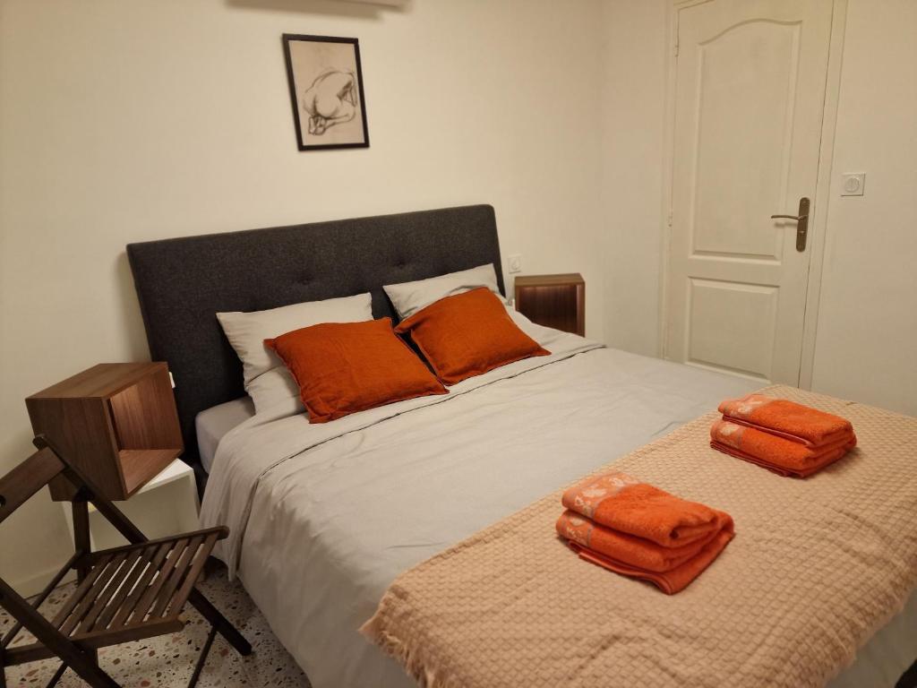 a bedroom with a bed with orange towels on it at maison PING ,en face des arènes in Béziers