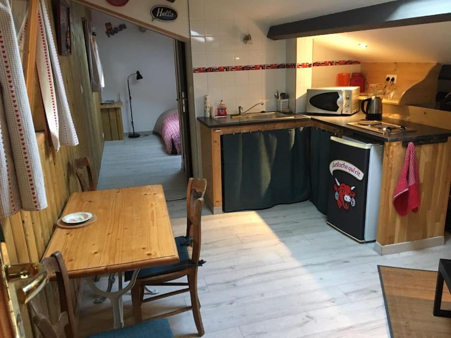 a kitchen with a wooden table and a table and a table and a dining room at Gîte Le Buron in Chazelles