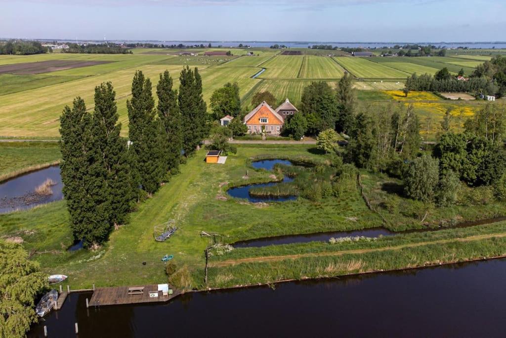 een luchtzicht op een huis op een eiland in een meer bij De Twee Zwanen in Delfstrahuizen