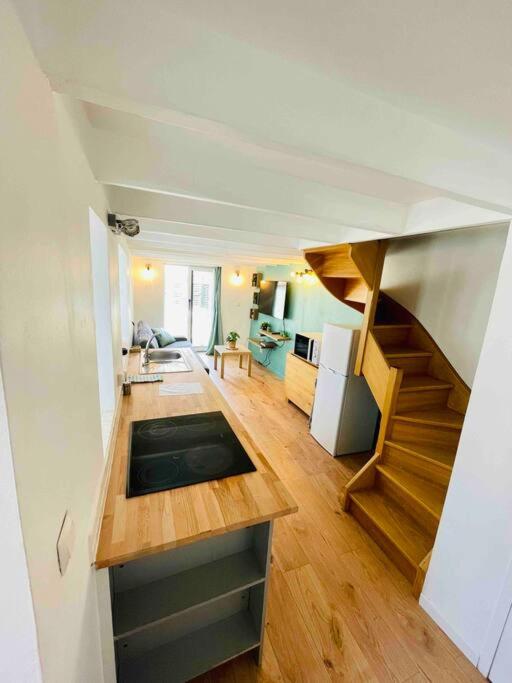 ein Wohnzimmer mit einer Treppe und eine Küche in der Unterkunft Maisonnette au cœur de Faremoutiers in Faremoutiers