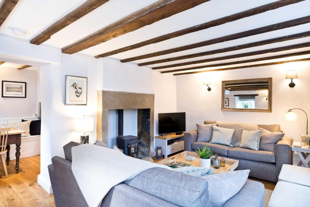 a living room with a couch and a fireplace at Applehoe Cottage in Bakewell