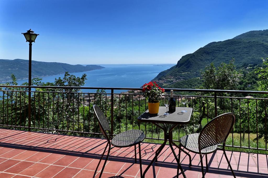 a table and chairs on a balcony with a view of the ocean at Appartamento Le Coste piano terra in Tignale