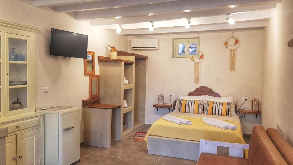 een slaapkamer met een bed en een tv. bij ALEMINAS HOUSE in Symi