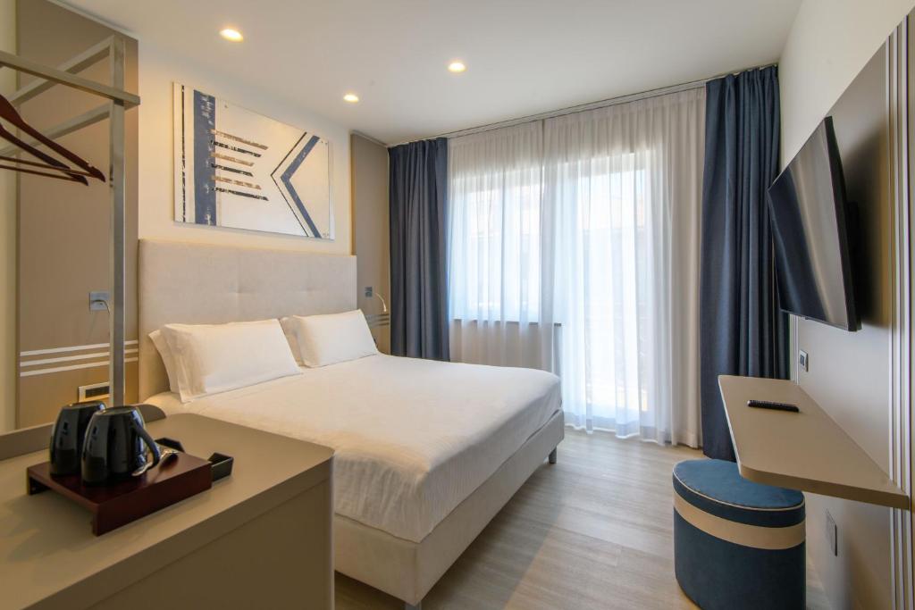 um quarto de hotel com uma cama e uma televisão em Hotel & Apartments Sasso em Diano Marina