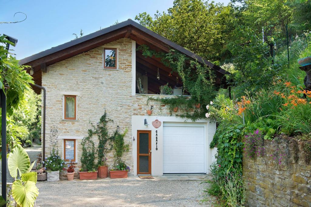 a brick house with a white garage at Casafiò Grotta in Cassinasco