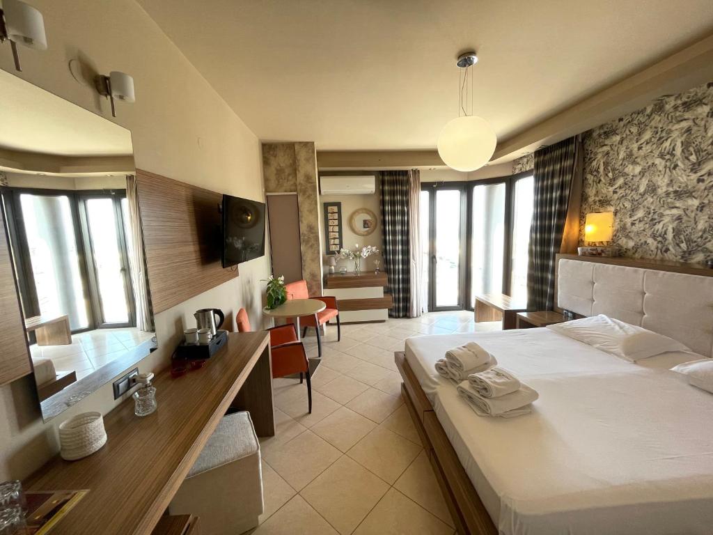 una camera con letto e sala da pranzo di Porto Del Sol Hotel a Paralia Katerinis