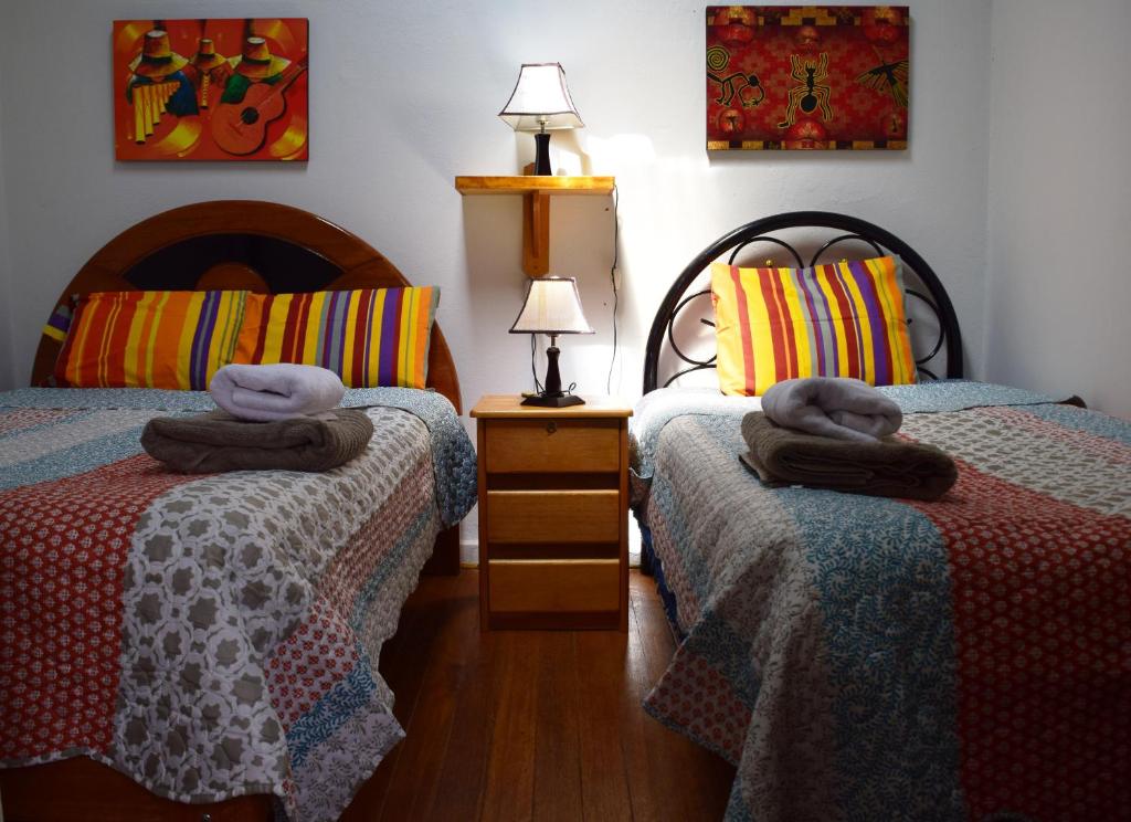 a bedroom with two beds with towels on them at Carlos Guest House 1 Cusco in Cusco
