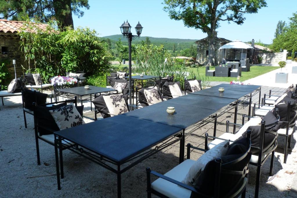 a group of tables and chairs with blue tables at Le Prieuré des Sources in La Répara