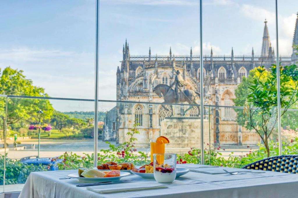 a table with food on it with a view of a building at Hotel Lis Batalha in Batalha