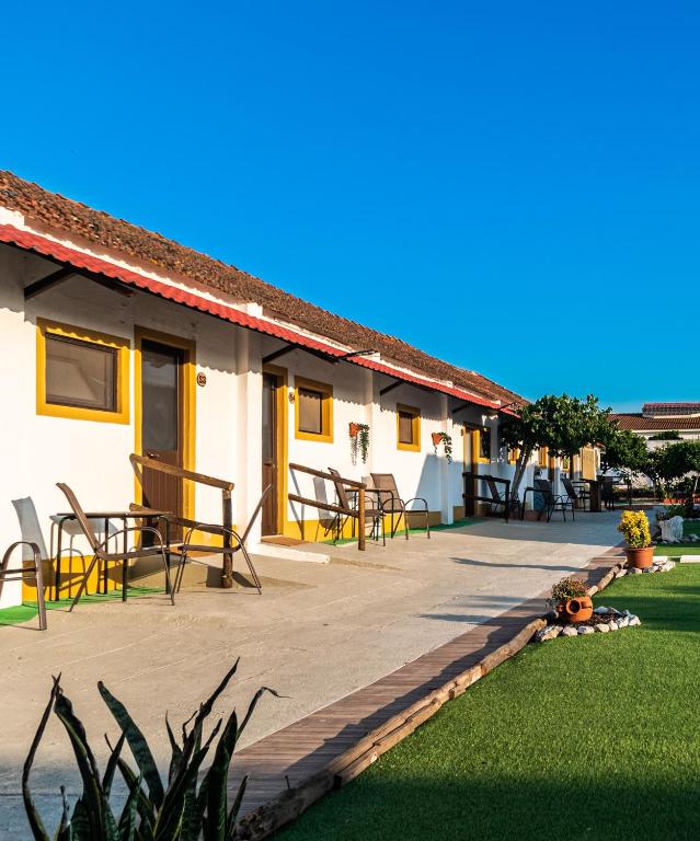 a patio with tables and chairs next to a building at VILA NATURA in Barreiro