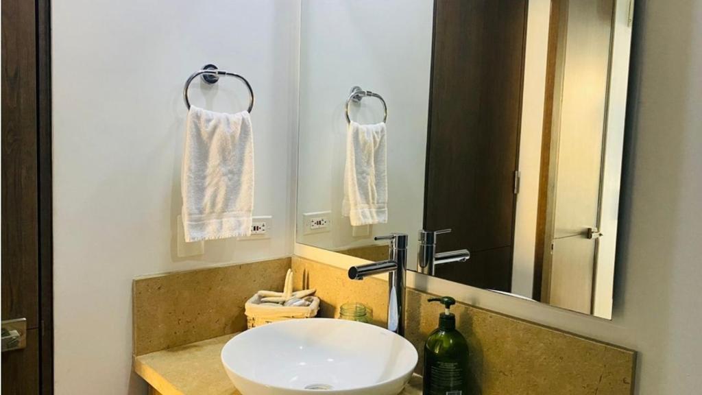 y baño con lavabo blanco y espejo. en Hermoso apartamento, en Cartagena de Indias