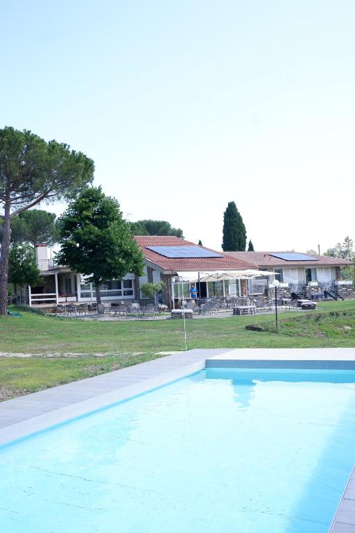 une grande piscine bleue en face d'une maison dans l'établissement Casa di Palaia, à Strada