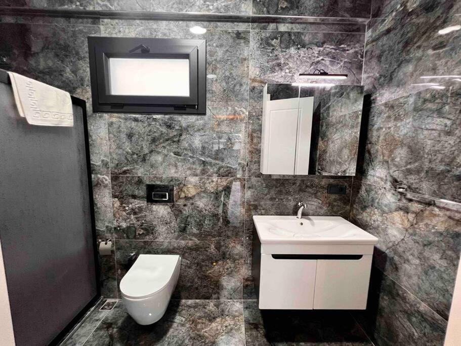 ein Bad mit einem Waschbecken, einem WC und einem Fenster in der Unterkunft Villa Ege 1 in Muğla