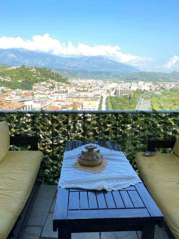 a table on a balcony with a view of a city at Aria Baci Guest House in Berat