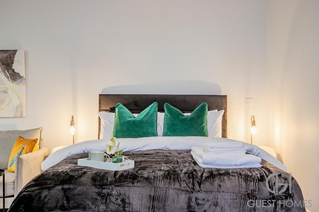 a bedroom with a large bed with green pillows at Host & Stay - Bridge Street Apartments in Evesham