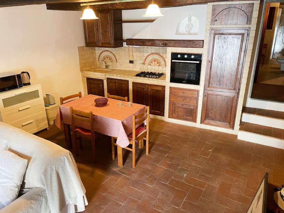 Appartamento toscano Pelago - Firenze في Pelago: مطبخ مع طاولة وكراسي في غرفة