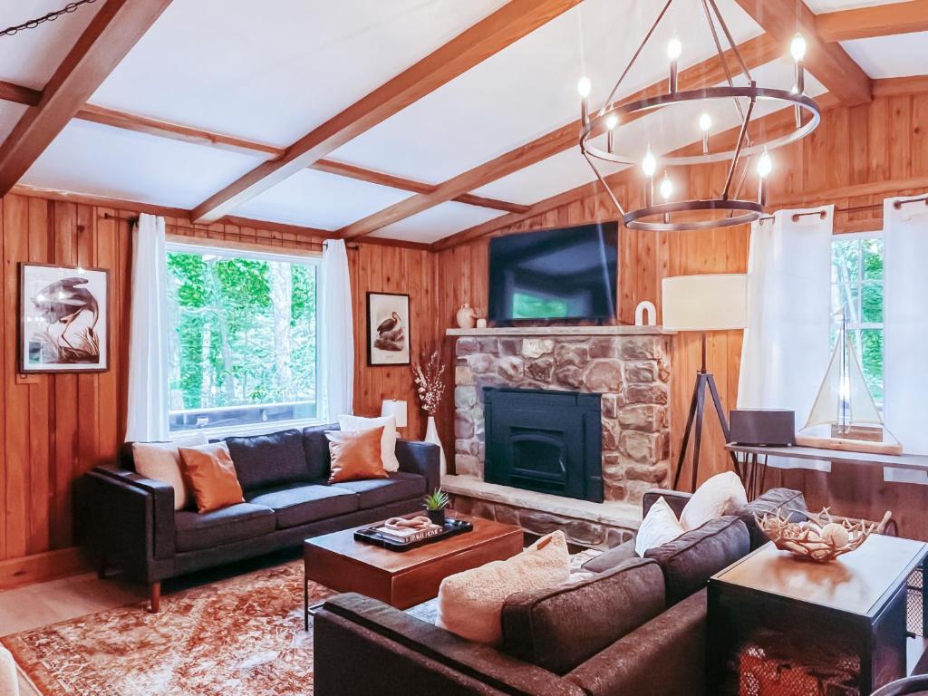 a living room with a couch and a fireplace at Stylish and Cozy Cabin, Walking Distance to Big Bass Lake in Gouldsboro