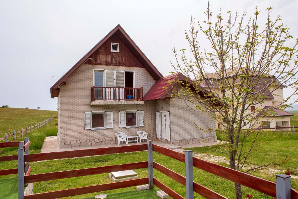 een huis met een hek ervoor bij Moticki Gaj Cottage in Žabljak