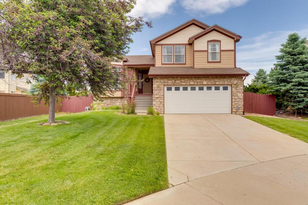 a house with a tree and a driveway at Spacious Aurora Home 20 Mi to Downtown Denver! in Aurora