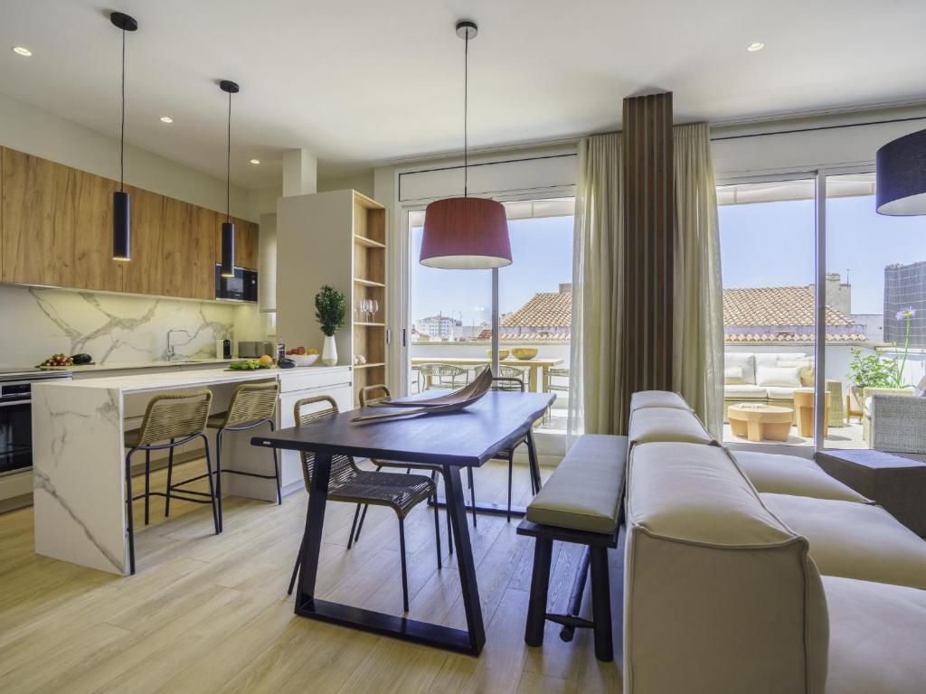a kitchen and living room with a table and a couch at Sitges Spaces Mediterranean Penthouse in Sitges