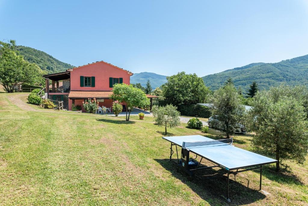 uma mesa de pingue-pongue no quintal de uma casa em Rifugio Arcobaleno em Popiglio