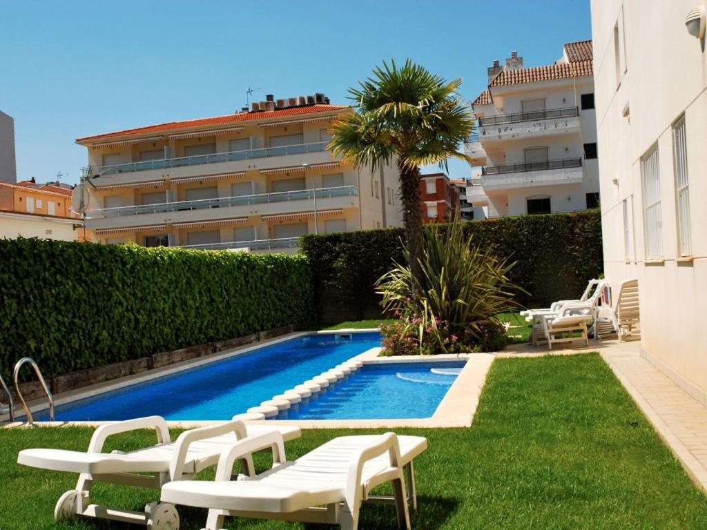 a swimming pool with chaise lounge chairs next to a building at Brises del Mar 3-3 in L'Estartit