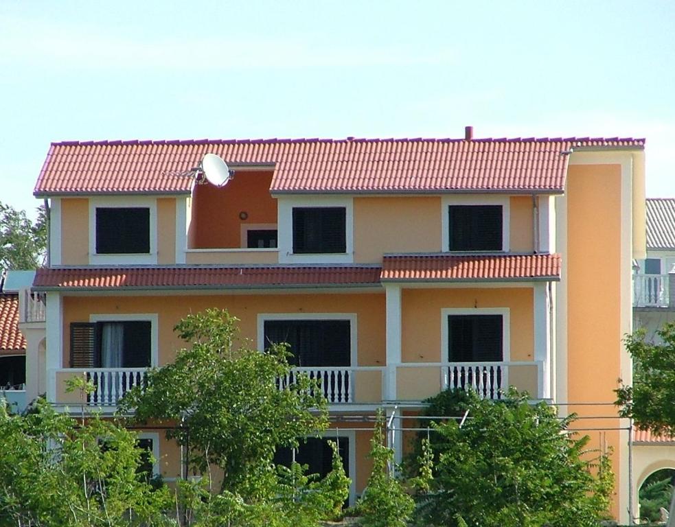 洛帕爾的住宿－Apartments Lidija，黄色的房屋,有红色的屋顶