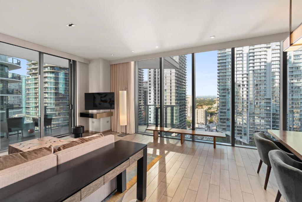 een woonkamer met een bank en grote ramen bij EAST Miami Residences in Miami