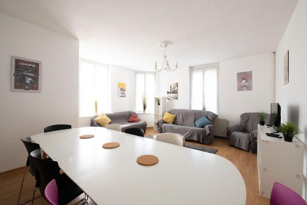 un salon avec une table et des chaises blanches dans l'établissement Maison cosy 4 chambres, terrasse, garage privé, à Croix