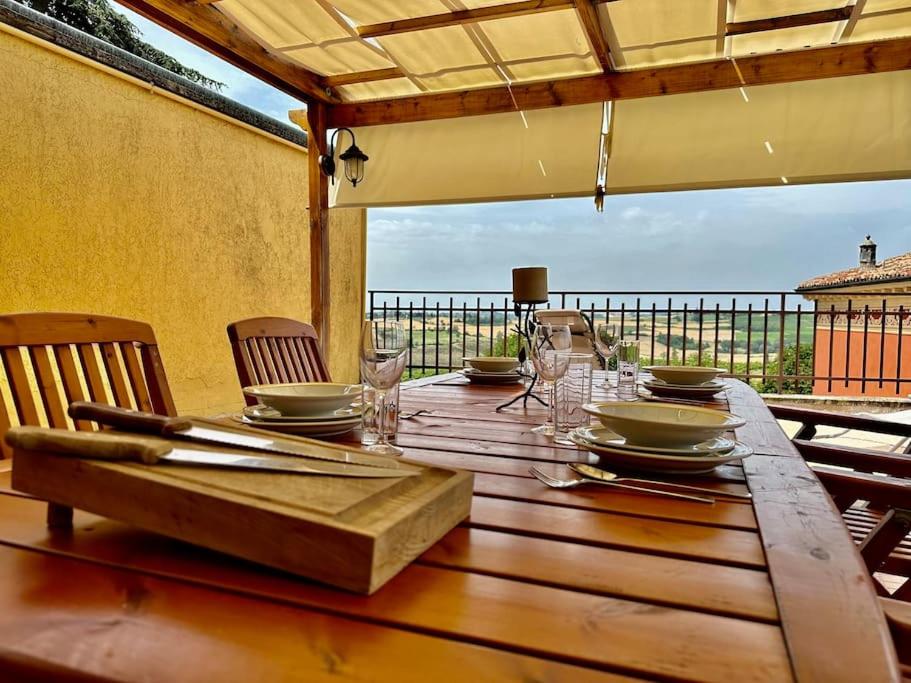 una mesa de madera con platos y copas de vino. en Fantastica terrazza con solarium e infernot by Revenue House, en Vignale