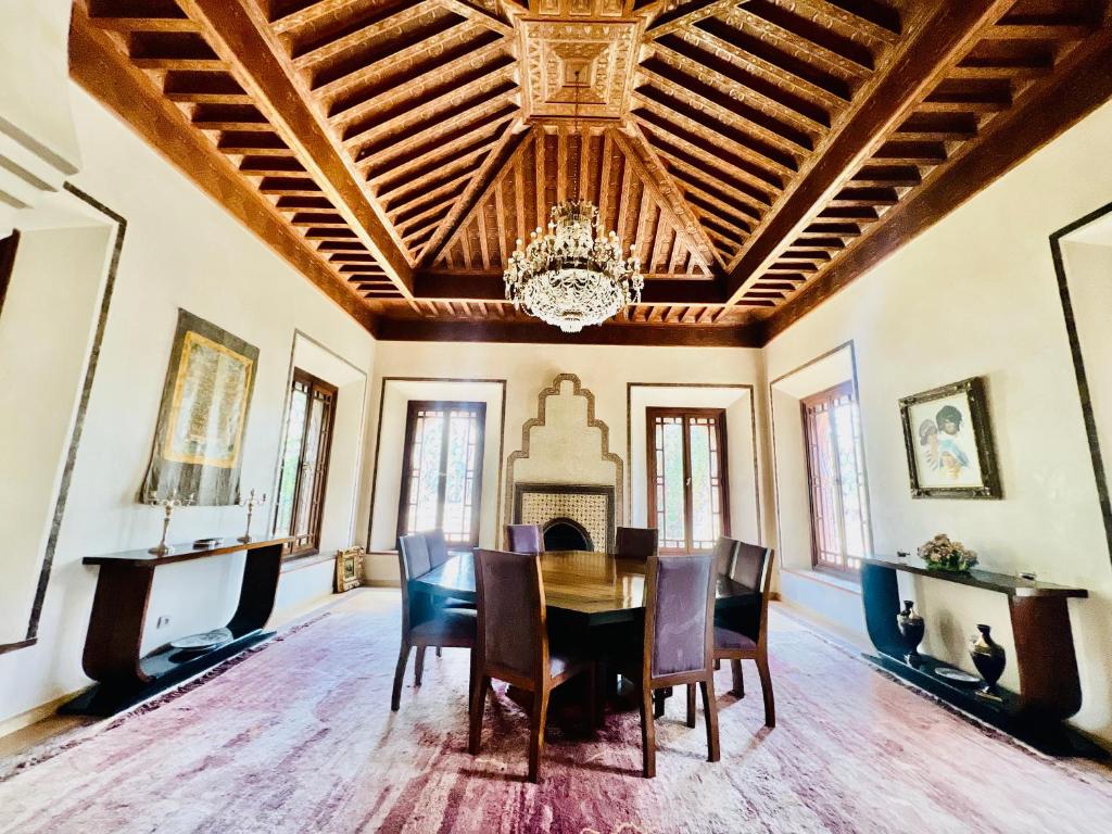 comedor con mesa, sillas y lámpara de araña en Majestic Luxury Villa Marrakech, en Marrakech