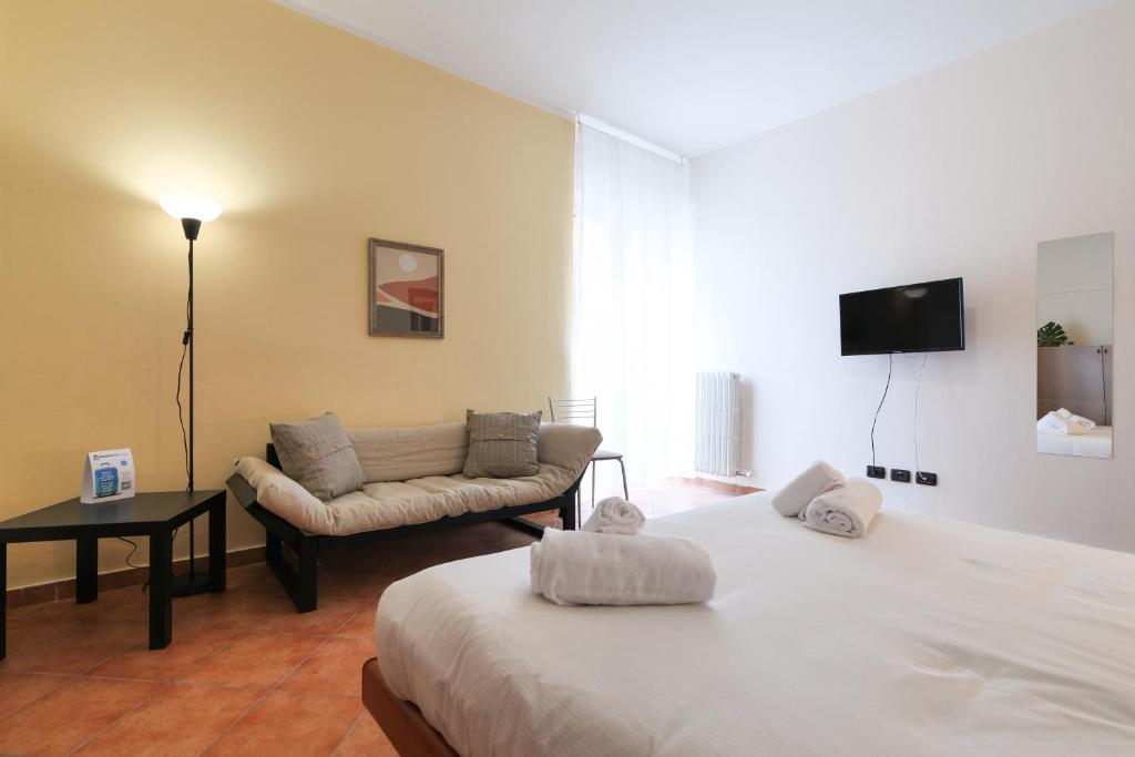 Habitación de hotel con cama y sofá en PrimoPiano - Dante, en Segrate