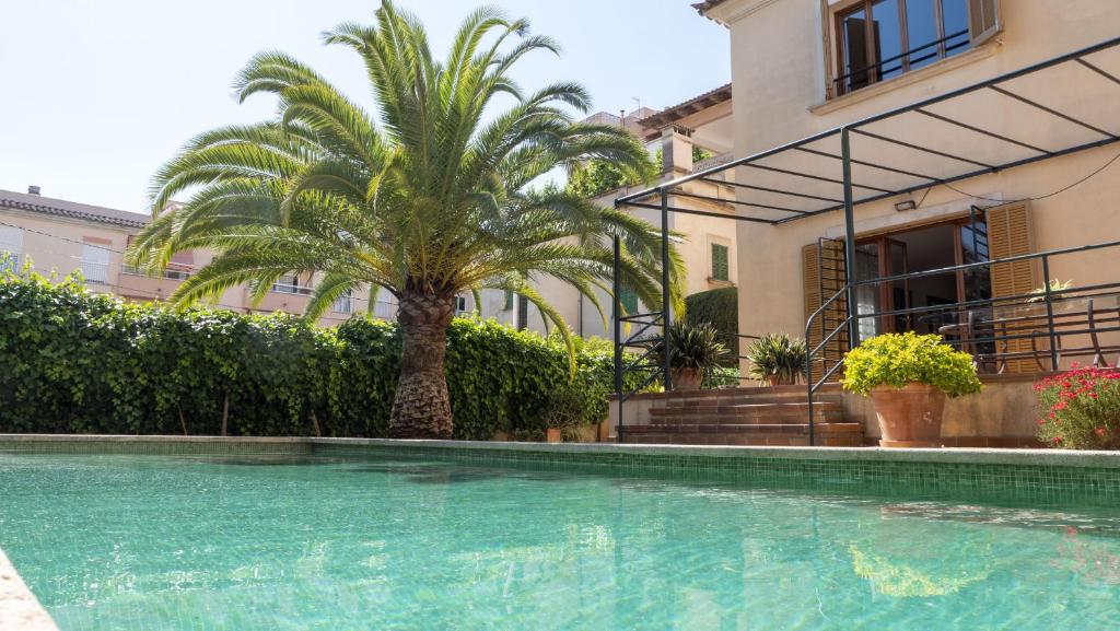 een huis met een palmboom en een zwembad bij Villa Palma 3 in Palma de Mallorca