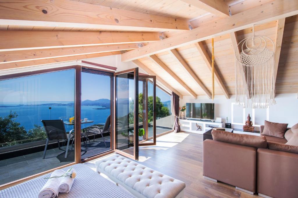a living room with a couch and a view of the ocean at Blue sky loft by Corfuescapes in Spartýlas