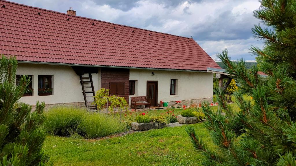 uma pequena casa branca com um telhado vermelho em Old Style Cottage em Horní Paseka