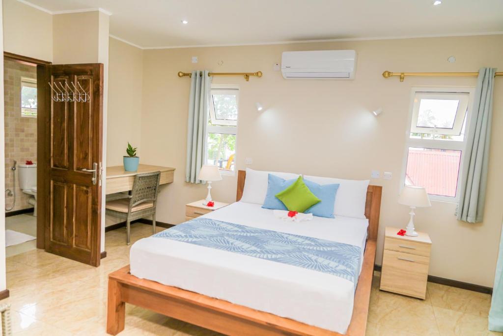 1 dormitorio con cama y escritorio en Jonc d'Or Villa Self Catering, en La Digue