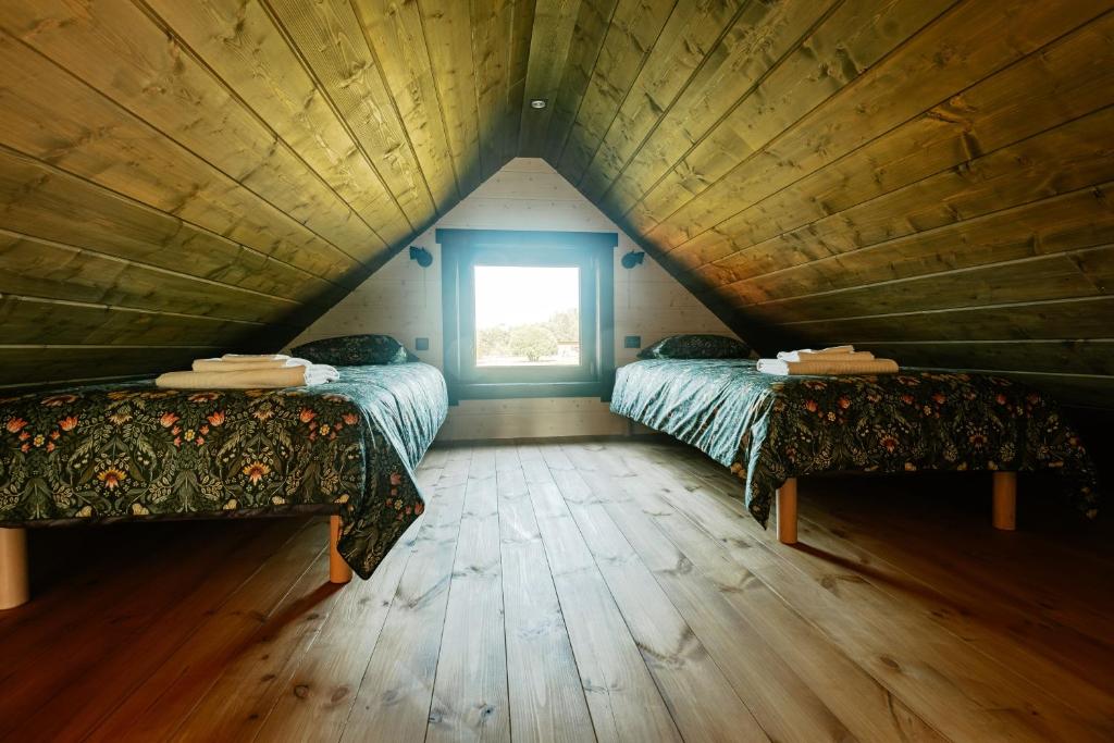 a attic room with two beds and a window at Tindioru Valley Resort in Rõuge