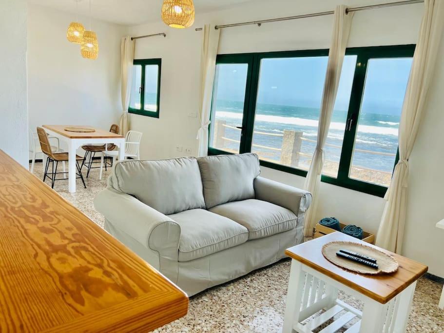 a living room with a couch and a view of the ocean at Famara Frontsea house in Famara